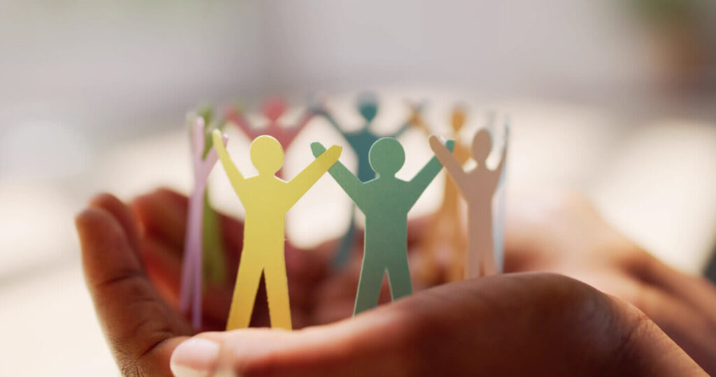 Representação de igualdade humana com figuras coloridas unidas nas mãos simbolizando união e diversidade