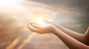 Mãos recebendo luz espiritual para ilustrar livros sobre mediunidade e estudo responsável da doutrina espírita.