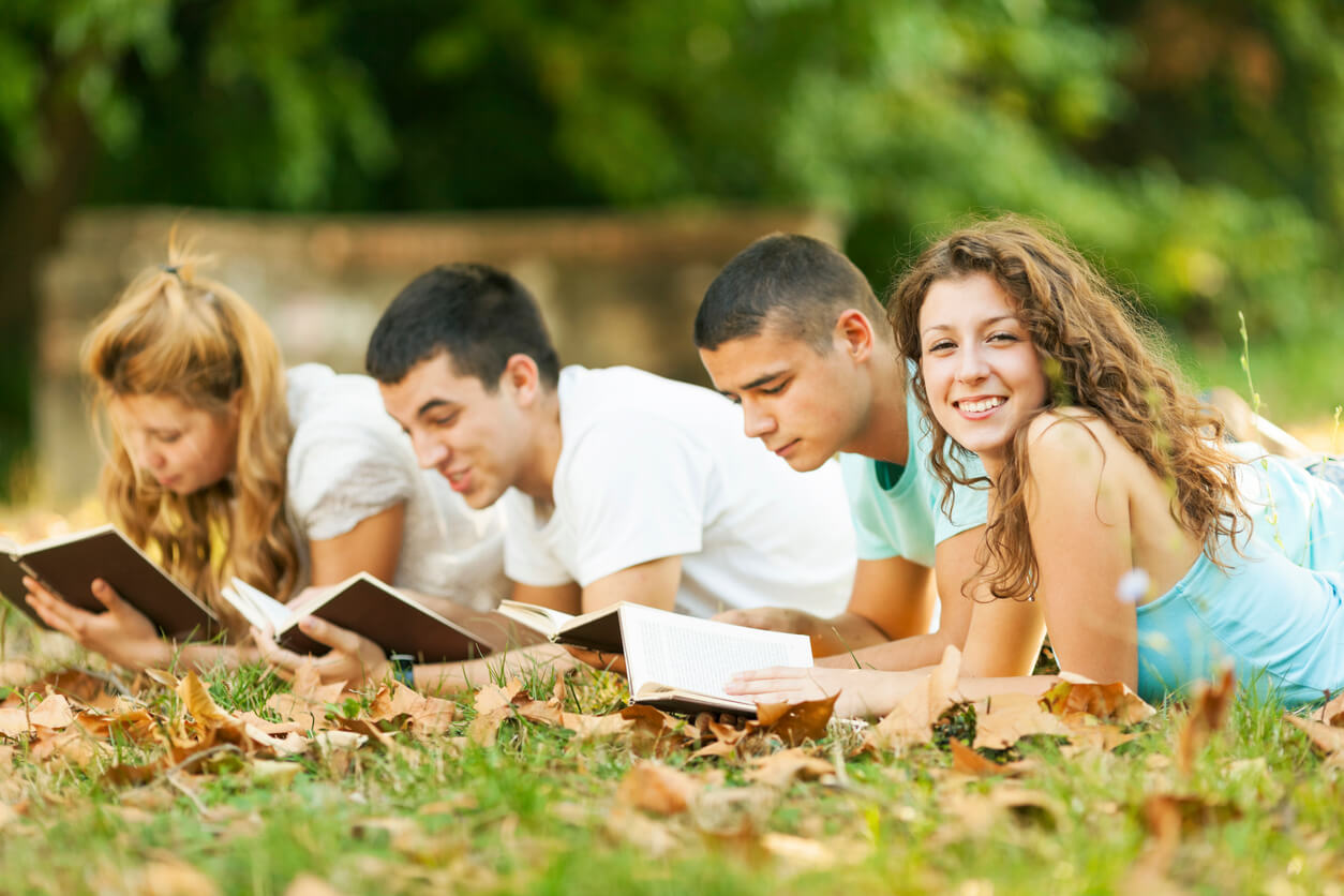Jovens lendo ao ar livre e refletindo sobre os princípios da doutrina espírita.