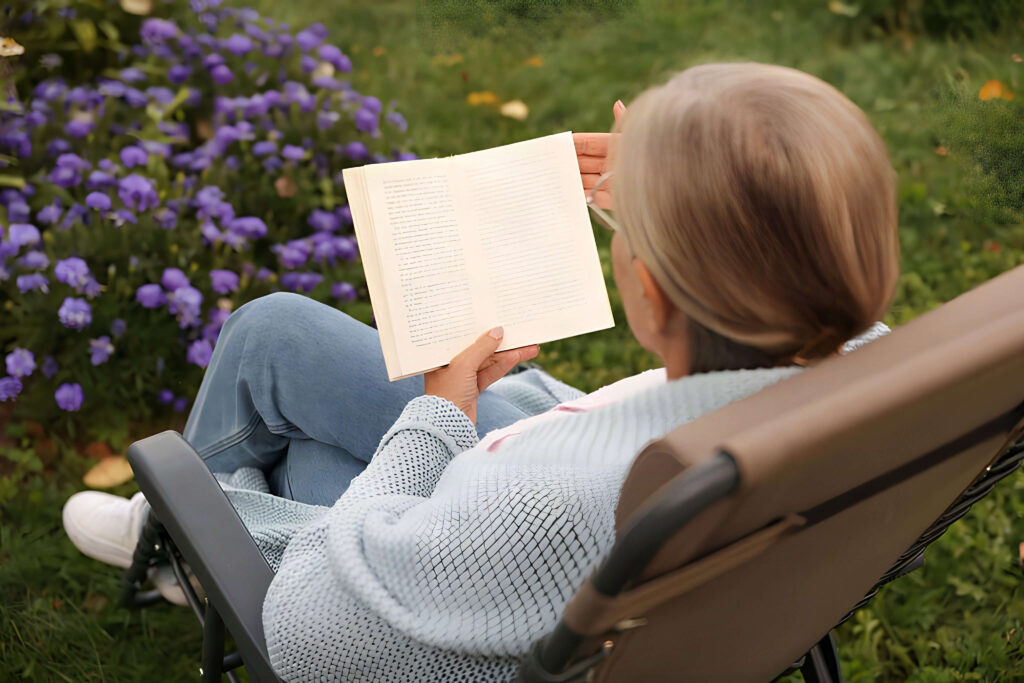 Mulher lendo livro ao ar livre sobre temas de Vera Lucia Marinzeck e vida espiritual